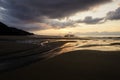 Beautiful summer golden sunset above the black sea with calm waves and reflection on the beach