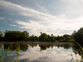 Beautiful summer lake scene outside trees clouds reflected in wa Royalty Free Stock Photo