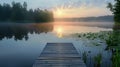 Beautiful summer lake with a wooden dock and reflections of the sunrise in the calm water Royalty Free Stock Photo