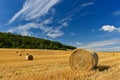 Beautiful summer landscape. Agricultural field. Round bundles of dry grass in the field with bleu sky and sun. Hay bale - haystack Royalty Free Stock Photo