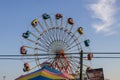 A beautiful summer landscape at the Carolina Beach Boardwalk with carnival rides, blue sky and clouds in Carolina Beach Royalty Free Stock Photo