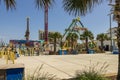 A beautiful summer landscape at the Carolina Beach Boardwalk with carnival rides, hotels, lush green palm trees and blue sky Royalty Free Stock Photo