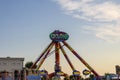 A beautiful summer landscape at the Carolina Beach Boardwalk with carnival rides, lush green palm trees and grass, blue sky Royalty Free Stock Photo