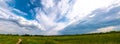 Beautiful summer landscape. Countryside with road on the field, green grass, trees and dramatic blue sky with fluffy clouds Royalty Free Stock Photo