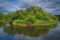 Beautiful summer landscape, forest trees are reflected in calm river water against a background of blue sky and white clouds Royalty Free Stock Photo