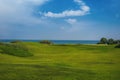 Beautiful summer landscape, green field blue sea and sky with clouds. Royalty Free Stock Photo