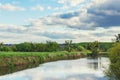 Beautiful summer landscape, green grass along the river and cloudy sky Royalty Free Stock Photo
