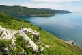 Beautiful summer landscape of Lake Baikal. A traveler girl stands on a mountain Royalty Free Stock Photo