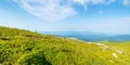 green grassy meadow on the hill side. view in to the distant range beneath a blue sky Royalty Free Stock Photo