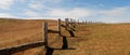 Wooden fence in steppe, blue sky with clouds. Royalty Free Stock Photo