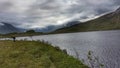 Beautiful summer mountain fishing lake with fisherman in the far back Royalty Free Stock Photo