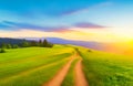 Beautiful summer mountain rural landscape with dirt road and Sunset cloudy sky Royalty Free Stock Photo
