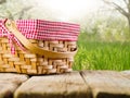 Beautiful summer nature. A cozy picnic basket rests on a simple wooden table. Camping, date, family vacation. Environmental Royalty Free Stock Photo