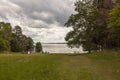 Beautiful summer nature landscape view. Greengrass field on front and Baltic sea on cloudy sky background