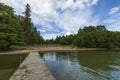 Beautiful summer nature landscape view. Lake coast line on green forest trees and blue sky with white clouds background Royalty Free Stock Photo