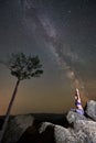 Beautiful summer night in mountains. Girl sitting alone on top of huge boulder doing yoga Royalty Free Stock Photo