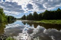 Beautiful summer river at sunny day with clouds reflection in the water Royalty Free Stock Photo