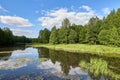 Beautiful summer river at sunny day with clouds reflection in the water Royalty Free Stock Photo