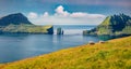 Beautiful summer scenery. Adorable summer scene of Faroe Islands and Tindholmur cliffs on background.