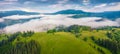 Beautiful summer scenery. Morning fog spreads on the mountain valley. Panoramic summer scene of Carpathian village Royalty Free Stock Photo