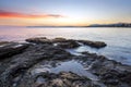 Beautiful summer. Sea coast spangled by stone, the sunrise is reflecting on the wet sand. Morning landscape. High waves with foam Royalty Free Stock Photo