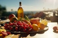 Beautiful summer still life with a bottle of wine, fresh fruits, and flowers on a table set outdoors Royalty Free Stock Photo