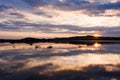 Beautiful summer sunset with cloudy sky and setting sun on the river. Royalty Free Stock Photo