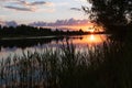 Beautiful summer sunset and colorful sky over the river. Clouds are reflected in the water. Royalty Free Stock Photo