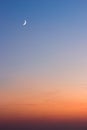 Beautiful summer sunset - dark blue sky with visible moon and orange horizon Royalty Free Stock Photo