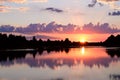 Beautiful summer sunset and pink sky over the river. Clouds are reflected in the calm water. Royalty Free Stock Photo