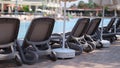 Beautiful sun loungers by pool in nature against backdrop of hotel Royalty Free Stock Photo