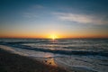 Beautiful sun rise and sea waves foam closeup at sandy beach with seashells tropical island. Waves in ocean at sunset light. Royalty Free Stock Photo