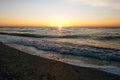 Beautiful sun rise and sea waves foam closeup at sandy beach with seashells tropical island. Waves in ocean at sunset light. Royalty Free Stock Photo