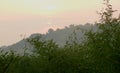 Beautiful Sun rise seen through trees and hill Royalty Free Stock Photo
