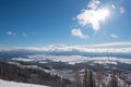 Beautiful sun shining though a cloud over valley covered in snow