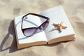 Beautiful sunglasses, book and starfish on sand Royalty Free Stock Photo