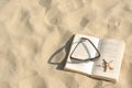 Beautiful sunglasses, book and starfish on sand, above view. Space for text Royalty Free Stock Photo