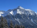 Beautiful sunlit and snow-capped alpine peaks above the tourist sports-recreational winter resorts of Valbella and Lenzerheide Royalty Free Stock Photo