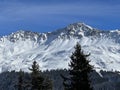 Beautiful sunlit and snow-capped alpine peaks above the tourist sports-recreational winter resorts of Valbella and Lenzerheide Royalty Free Stock Photo
