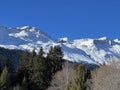 Beautiful sunlit and snow-capped alpine peaks above the tourist sports-recreational winter resorts of Valbella and Lenzerheide Royalty Free Stock Photo