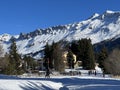 Beautiful sunlit and snow-capped alpine peaks above the tourist sports-recreational winter resorts of Valbella and Lenzerheide Royalty Free Stock Photo