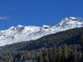 Beautiful sunlit and snow-capped alpine peaks above the tourist sports-recreational winter resorts of Valbella and Lenzerheide Royalty Free Stock Photo