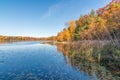 Beautiful sunny autumn day on small remote lake in Northern Wisconsin - fall colors and reflection of trees on calm lake waters Royalty Free Stock Photo