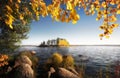 Beautiful autumn island in frame of golden leaves and stones. Fall in Vyborg bay, gulf of Finland Royalty Free Stock Photo