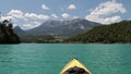 Beautiful sunny day for kayaking at emerald lake. Wonderlust view of highland lake with forest and mountain under the