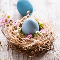 Beautiful, sunny easter greeting card - with blue colored eggs and a natural nest