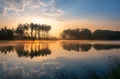 Beautiful sunrise above lake in KrasnobrÃÂ³d, Roztocze, Poland. .Trees reflecting in the water in the early morning. A small health