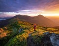 Beautiful sunrise on the autumn morning. Landscape with high mountains. Successful tourist is standing at the path in orange Royalty Free Stock Photo