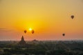 A beautiful sunrise with balloons floating in the air in Bagan is a city of thousands of Buddhist pagodas. Royalty Free Stock Photo