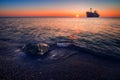 Beautiful sunrise on a beach at sea with a ship wreck in the background